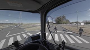 この画像はVRのワンシーンです。正面から右サイドミラーを見ると人が映っていません。しかし、実際に右を向くとトラック後方から人が横断歩道を渡ろうとしている様子を確認することができます。このように、リアルに近い事故状況を再現し、ドライバーに疑似体験していただくことで事故を抑制します。