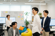 職種を越えて笑顔で議論。心理的安全性と速い検証サイクルで、アイデアを“成果”に変える文化があります。
