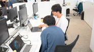 「互いの画面を確認しながらアイデアを出し合う、日常の技術ディスカッション風景です。