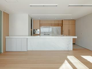 多様な素材を組み合わせ、複雑な条件をクリアしながら製作したオーダーキッチン。設備機器一式はハイブランドメーカーのGAGGENAU（ガゲナウ）をチョイス。ハイエンドなユーザー様の希望を具現化。冷蔵冷凍庫はLIEBHERRを使用しビルトインにて設置、家具と同等の仕上げをすることで存在感を無くします。