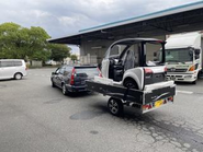 トレーラーで救急車でトゥクトゥクを運ぶ様子です。