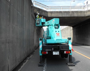 道路を跨ぐ道路橋の定期点検。コンクリートの剥離やヒビなどを点検する。高いところは高所作業車等を用いてモレの内容に点検する。