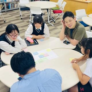 先生と生徒が同じ席につき、フラットに意見を交わし合うワークショップ風景。上から指導するのではなく、等身大の人間として同じ目線に立ち、「正解のない問い」をともに面白がりながら考え抜くカルチャーがここにあります。