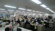 ワンフロアに100名ほどの仕事場。20代～40代まで幅広い年齢層。部長や社長も「さん」付けでフランクな社風です。