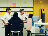 スタンディングデスクで、、次の１週間の仕事の優先順位を話し合うmtg。