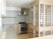 BERTAZZONI（ベルタゾーニ）のコンロとオーブンを採用したオーダーメイドキッチン。手前の３面使いのガラス扉の収納はArnoならではの複雑構造、設計の意図を汲み取りデザインを具現化するのはArnoのアドバンテージポイント。