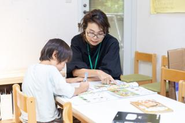 英語の宿題をサポートする保育スタッフ