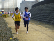 伴走ランナーと走っている知的障がいのあるこうじくん。宝塚ハーフマラソンのファミリー３キロを1位で完走しました。