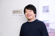 会社のネームプレートの前で代表の堀口を撮影しました