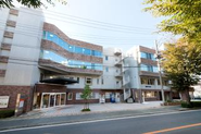【ゆうしん本社外観】ゆうしんは熊本市東区錦ケ丘に位置しています。すぐ近くには健軍自衛隊通りがあり、春になると満開の桜並木が見られるため、ご利用者様と散歩に行くこともあります。