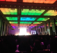 全社員が集まる4月のビジョンミーティングで目標達成表彰式を行っている写真です。目標達成した部門は一人一人名前が呼ばれ檀上でグループ代表の鳥居と握手をして目録を受け取ります。