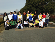 定期練習会での集合写真。知的障がい者は手をつなぐ、声掛けなどでサポート。身体障がい者は足こぎ車いすでサポートしています。