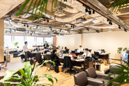 当社のオフィス。「気持ちよく働けるオフィスで仕事をしたい！」という社員の声が反映され、カフェのような清潔感があり開放感溢れるオフィスになりました。自分の固定デスクは無く、全員フリーアドレスでログイン。毎日好きな席でリラックスしながら仕事をしています。