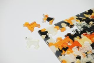 犬の形のピースをしたアクリルパズル「Dogs」――伝統的な「キ型」ピースにとどまらず、Tシャツ、犬、猫、スニーカーなどユニークな形状のピースを取り入れたパズルを制作しています。