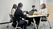 若手メンバーが会議室で作業している様子