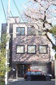 大きな桜の木が見えるレンガ造りのオフィスです