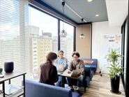 カフェブースにてプロジェクト進捗を確認するメンバー（京都オフィス）